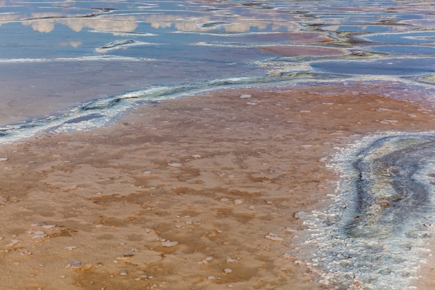 The crust of salt on the bottom of the curative mud dry lake. The surface of the salt lake.