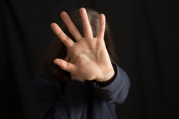 A crying woman covers her face with her hand . The  of domestic violence. 