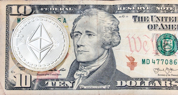 Cryptocurrency Ethereum next to the face of a 10 dollars bill of the united states president next to a map of the united states