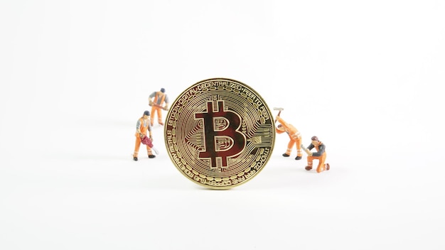 Cryptocurrency mining concept miniature worker on various golden physical digital money bitcoin