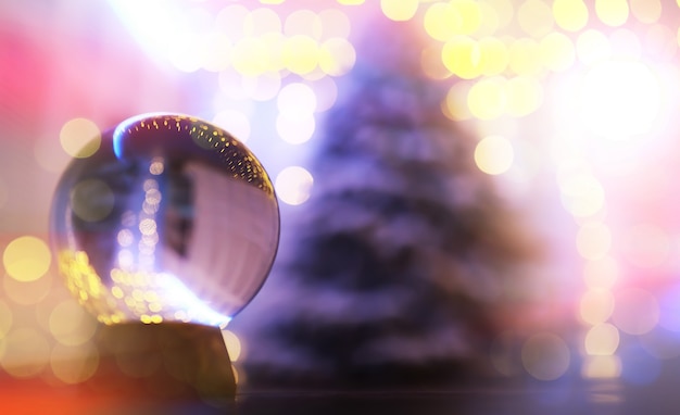 Crystal Ball on the floor with bokeh, lights behind. Glass ball with colorful bokeh light, celebration concept.