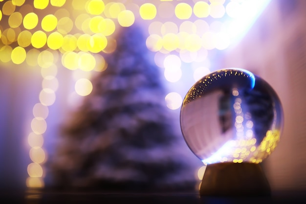 Photo crystal ball on the floor with bokeh, lights behind. glass ball with colorful bokeh light, new year celebration concept.