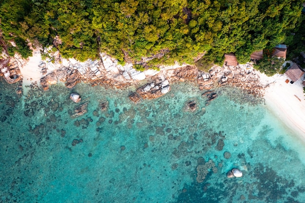 Crystal clear blue water at tropical island bird's eye view