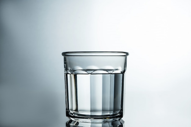 Crystal clear water. Purified water in a glass on a gray table. Pure water concept.