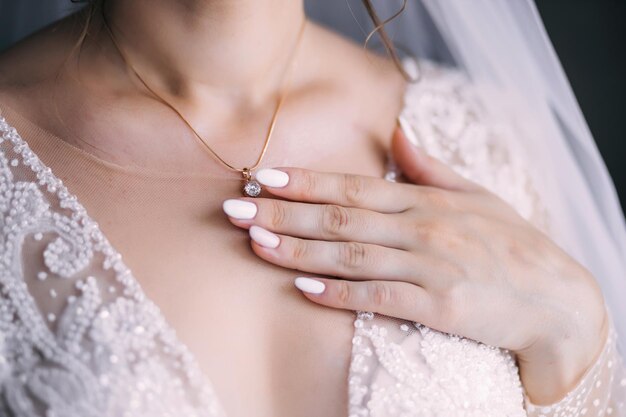 Crystal decoration on the bride's chest The girl touches her collarbone Beautiful female shoulders body skin Decoration details