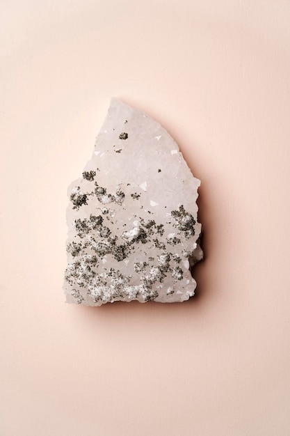 Crystal stone on pink background with copy space top view Mineral stone