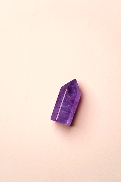 Crystal stone on pink background with copy space top view Mineral stone