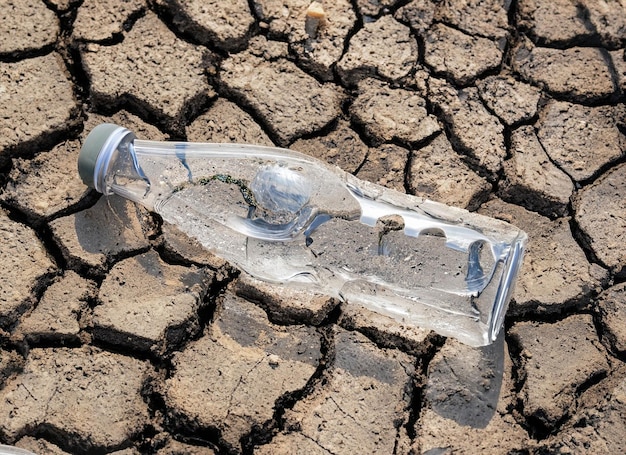 crystal Water bottle on dry soil with dry and cracked soil