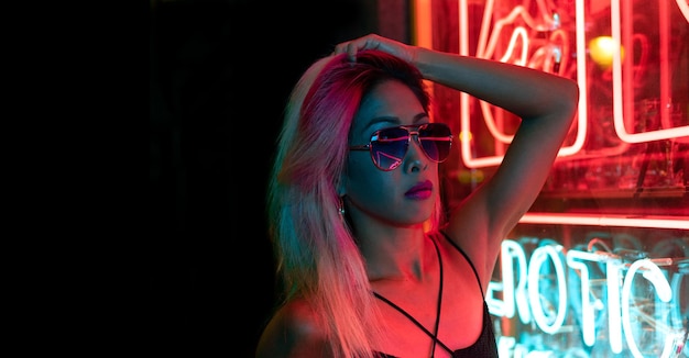 CU Night portrait of Asian standing in the streets filled with neon lights. neon background