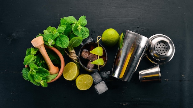 Cuba libre cocktail glass Lime mint On a black wooden background Free space for text