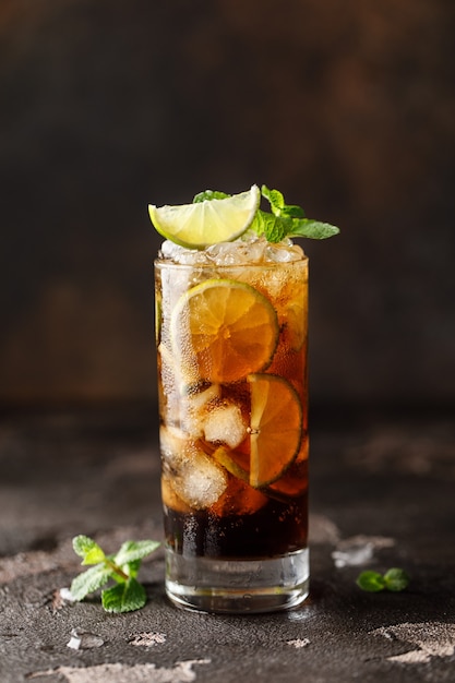 Cuba Libre with brown rum, cola, mint and lime. Cuba Libre or long island iced tea cocktail with strong drinks