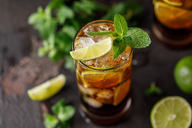 Cuba Libre with brown rum, cola, mint and lime. Cuba Libre or long island iced tea cocktail with strong drinks