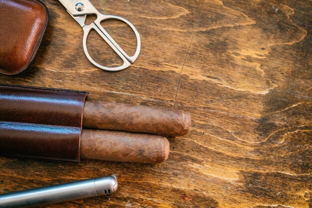 Cuban cigars and smoking accessories on wooden desk