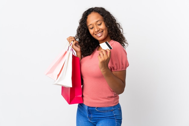 Cuban woman isolated on white holding shopping bags and a credit card