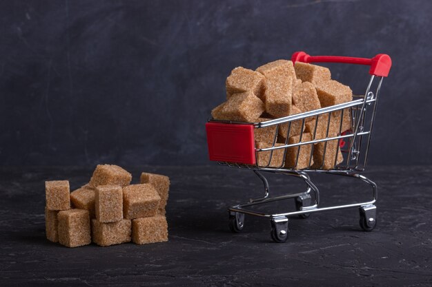 Cubes of cane sugar in a trolley and a pile of cubes next to