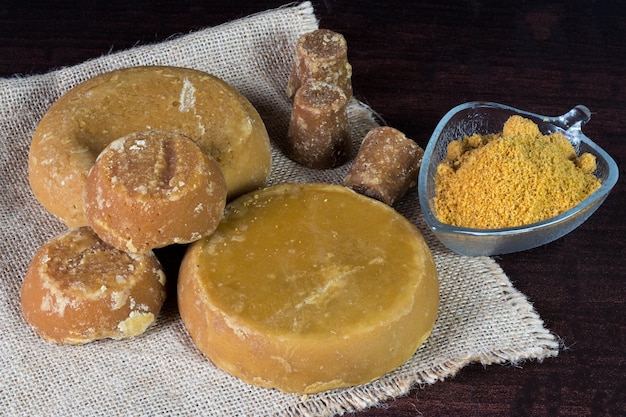 Cubes and powdered Panela or sweet sugar cane with wooden background typical food of Colombia