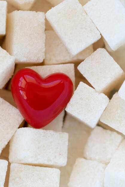 Cubes of sugar with a red heart background