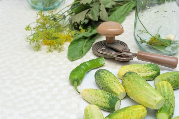 Cucumbers with green hot pepper and herbs on the table prepared for conservation Selective focus Harvest fall preparations