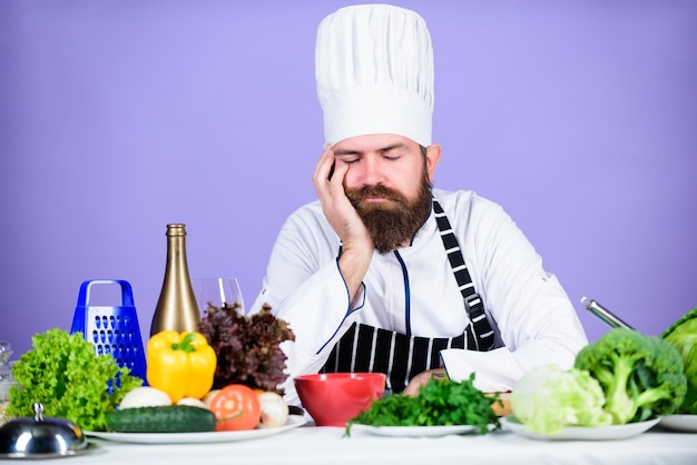 Culinary inspiration Hard day at restaurant Tired and exhausted chef Man bearded chef cooking food Chef fed up of boring meals Looking for inspiration Bored chef lean on table at kitchen