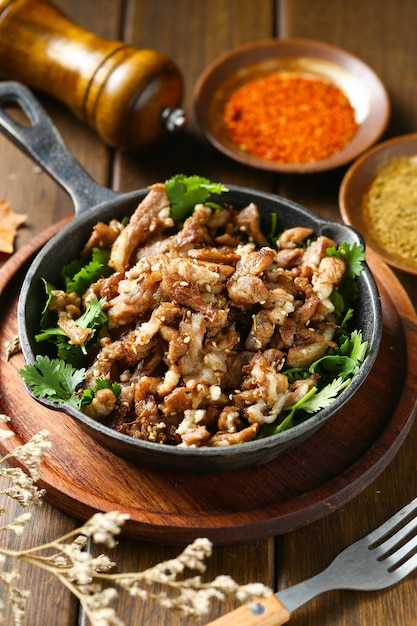 cumin fried lamb in pot on wooden table