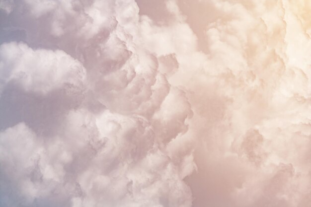 Photo cumulus fluffy clouds illuminated by orange sunlight as background abstract toned