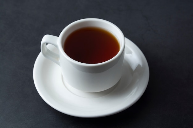 A cup of black tea isolated over dark  with copyspace.