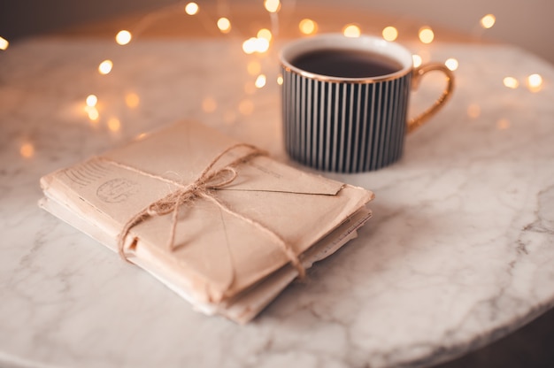 Cup of black tea with laced stack of old love paper letters