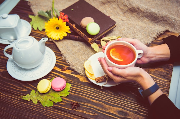 A cup of black tea with lemon warms the palms