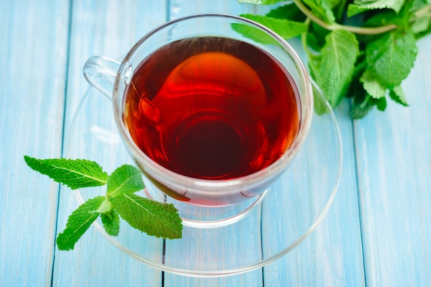 Cup of black tea with mint leaves