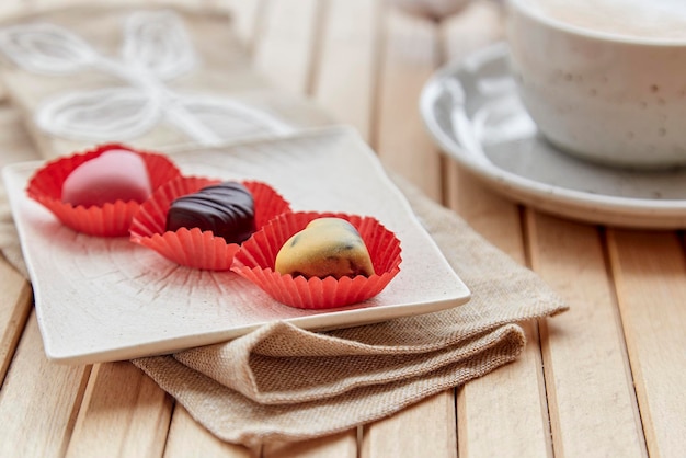 Cup of cappuccino and chocolate sweets hearts Aesthetic coffee time outside Romantic date Valentines day