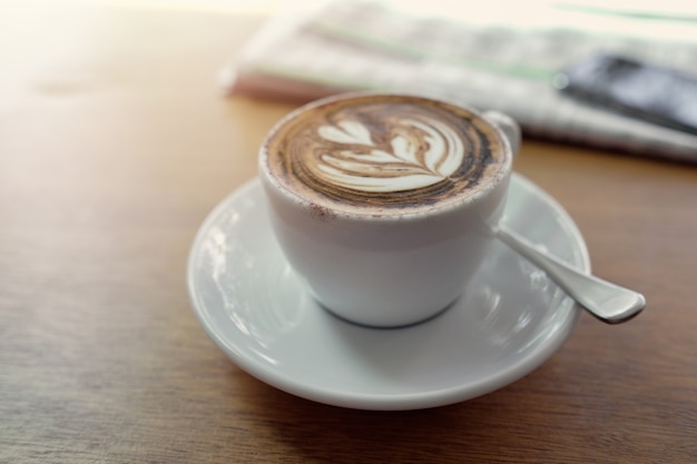 Cup of cappuccino coffee art with newspaper