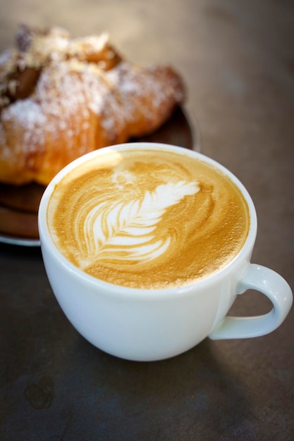 A cup of cappuccino coffee on a table in a cafe Coffee hot drink in a ceramic cup for breakfast in the morning