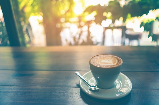 Cup cappuccino coffee on wood table and vintage life style chocolate on white cup