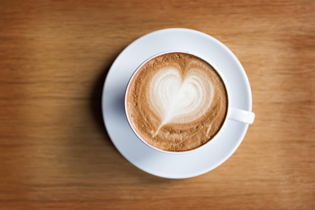 Cup of cappuccino on the wooden table background