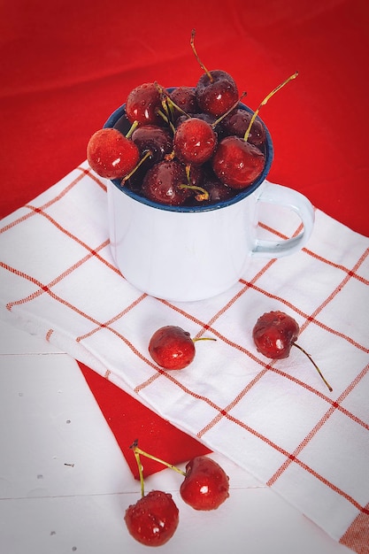 Cup of cherries on a red background