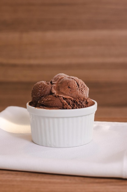 Cup of chocolate ice cream on a wooden table