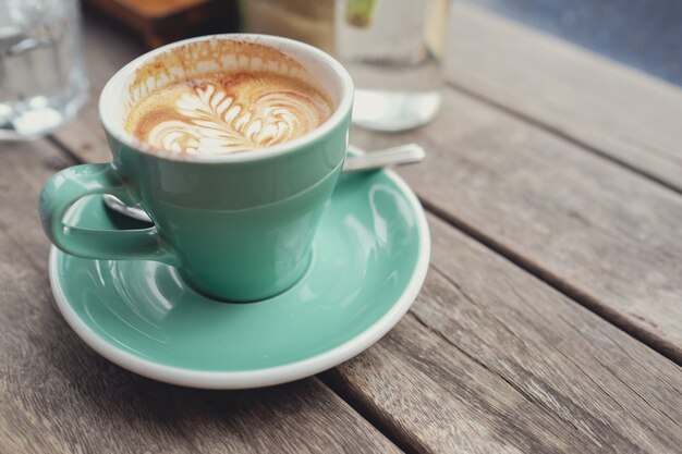 Cup of coffe latte art on wooden table