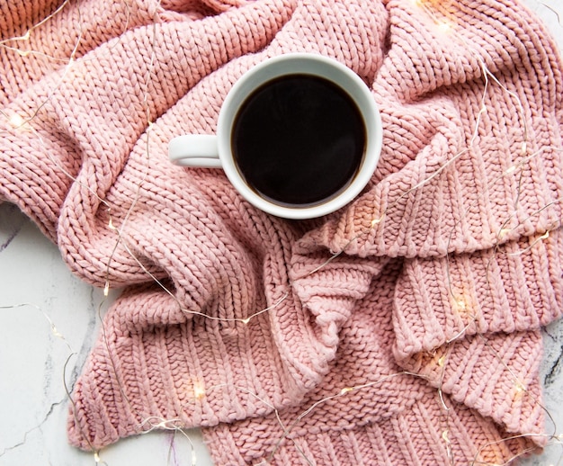 Cup of coffe sweater and garland flat lay