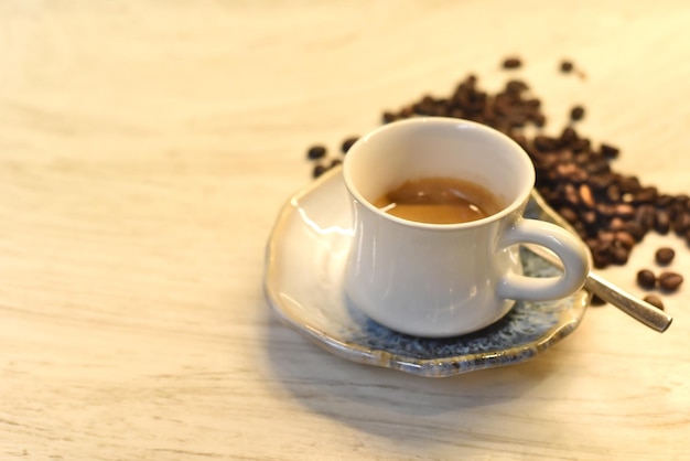 Cup of coffee against coffee beans on wooden table