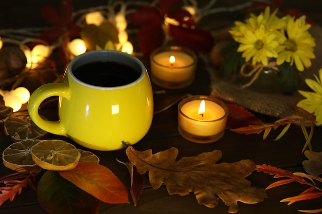 cup of coffee on the autumn background with leaves and flowers