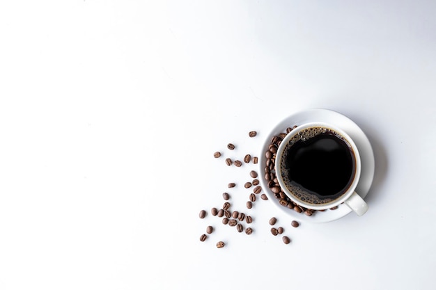 Cup of coffee and bean on white table background top view