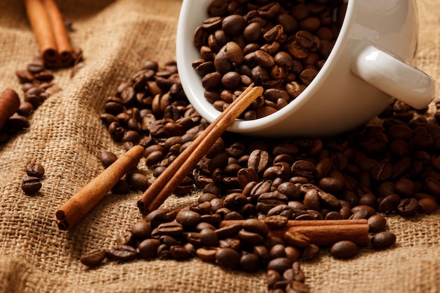 Cup, coffee beans and cinnamon sticks