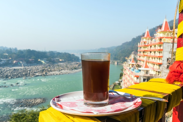 A Cup of coffee on a beautiful background of the city Rishikesh. Tourist Indian Breakfast at early morning in the Himalayan mountains.