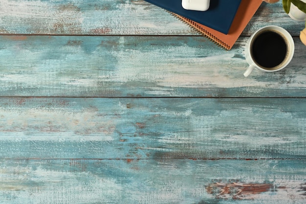 A cup of coffee books and potted plant on rustic wooden table Top view with copy space for your advertise text