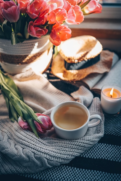 A cup of coffee and a bouquet of flowers on a table