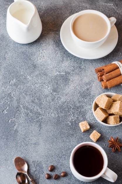 Cup of coffee, brown sugar and cinnamon with anise on concrete. Copy space