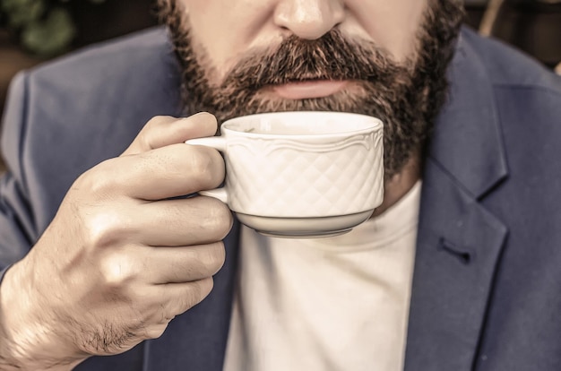 Cup of coffee Cappuccino and black espresso coffee cup Coffee drink Bearded man hands holding a hot coffe cups Coffe time