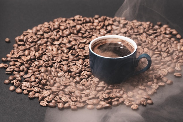 A cup of coffee and coffee beans on a black background an aromatic and energy drink