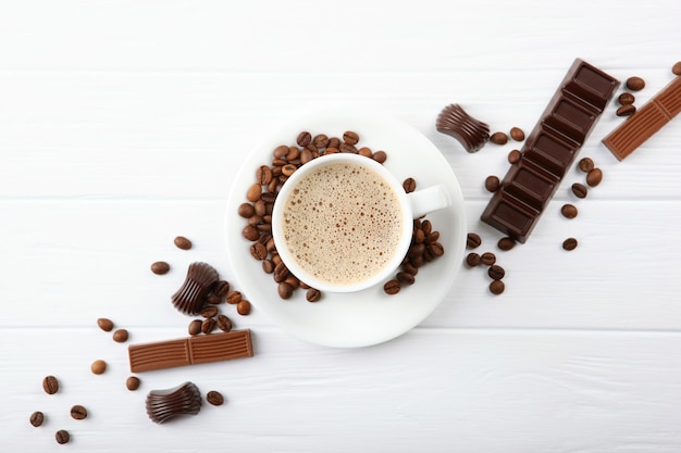 cup of coffee coffee beans and chocolate on the table close up