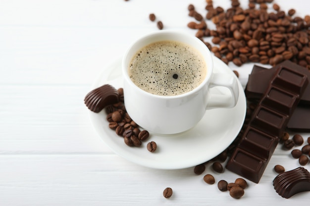 cup of coffee coffee beans and chocolate on the table close up